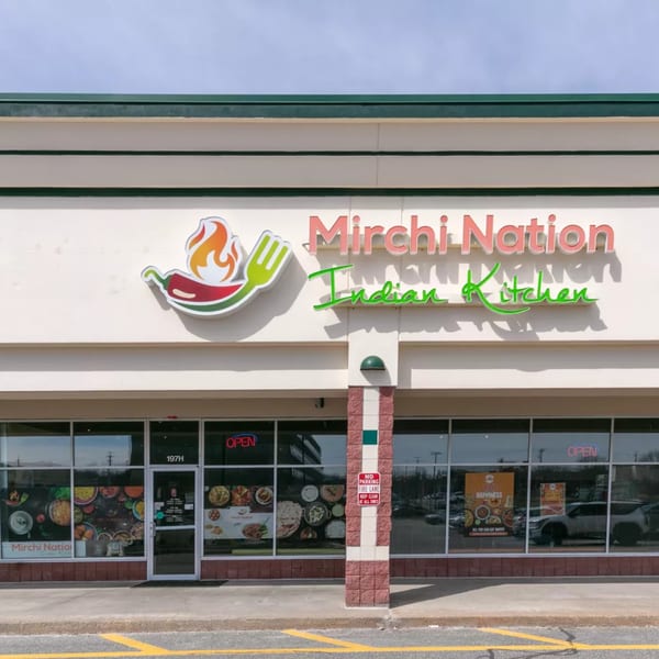 The exterior of Mirchi Nation Indian Kitchen, featuring its sign, storefront windows, and entrance.