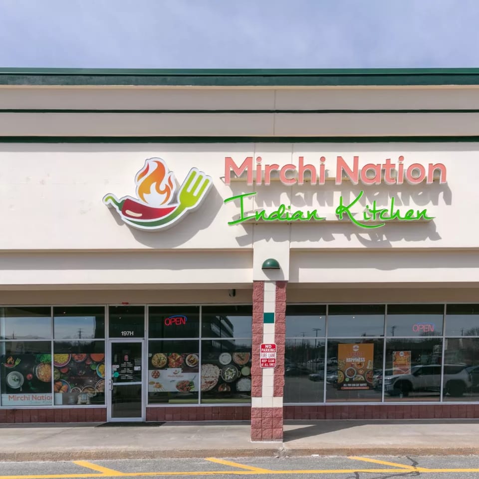 The exterior of Mirchi Nation Indian Kitchen, featuring its sign, storefront windows, and entrance.